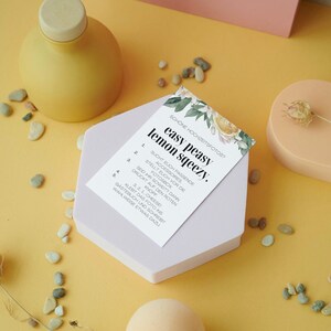 May include: A light purple hexagonal box with a white card on top. The card has a floral design and the text "easy peasy lemon sqeezy." with numbered instructions for taking photos.