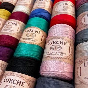 Op de afbeelding: Een set van drie keramische mokken met een gespikkelde, matte afwerking. De mokken zijn in crème, lichtgrijs en donkergrijs. Elke mok heeft een eenvoudig, modern ontwerp en een afgeronde handgreep.