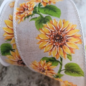 Peut inclure: Un ruban beige avec un motif répétitif de tournesols jaunes et de feuilles vertes.