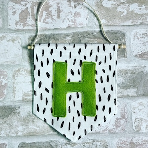 Wall hanging pennant flag with initial detail.