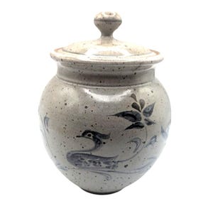 May include: A speckled, stoneware jar with a lid. The jar is light gray with blue floral and bird designs. The lid has a small knob. The jar is a decorative storage container.