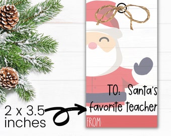 May include: A red and white Christmas gift tag featuring a cartoon Santa Claus illustration. The tag has the text "To: Santa's favourite teacher" and "From:" printed on it. The tag measures 2 inches by 3.5 inches.