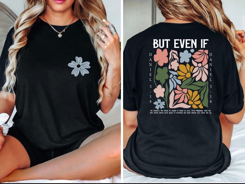 May include: Black t-shirt with a gray flower graphic on the front. The back features a floral design with the text "BUT EVEN IF" and "DANIEL 3:18". The shirt has a relaxed fit and short sleeves.