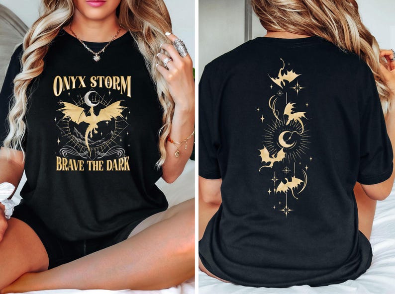 May include: Black t-shirt with a gold graphic of a dragon and the text "ONYX STORM" and "BRAVE THE DARK". The back of the shirt has a gold graphic of a crescent moon and several bats.