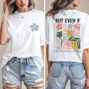 May include: White t-shirt with a blue flower graphic on the front and a floral design on the back. The back of the shirt has the text "BUT EVEN IF" and "DANIEL 3:18". The shirt is paired with denim shorts.
