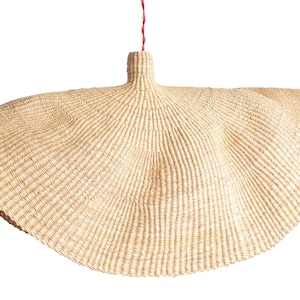 May include: A large, round, woven pendant light fitting made of natural straw with a red cord.