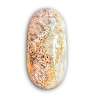 May include: An oval-shaped gemstone with a polished surface. The stone features a blend of colors, including beige, brown, and white, with a marbled appearance. The gemstone is likely used for jewelry or decorative purposes.