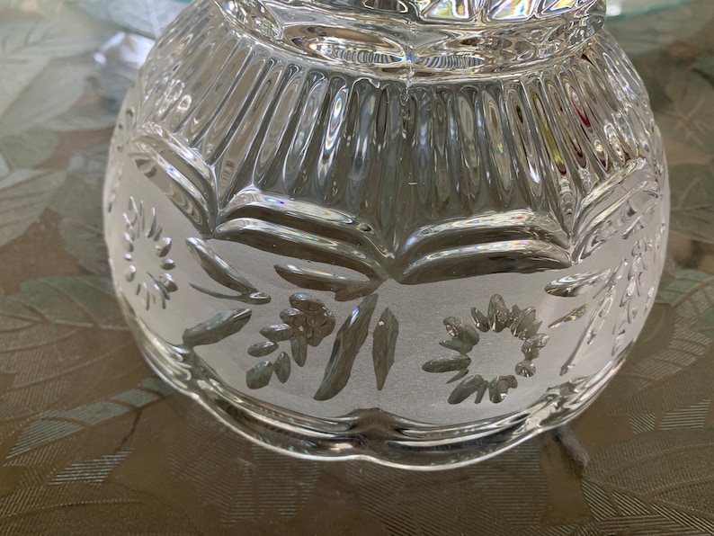 Peut inclure: Un bol en verre transparent avec un motif grav&eacute; d&eacute;coratif de fleurs et de feuilles. Le bol a un bord festonn&eacute; et une surface textur&eacute;e.