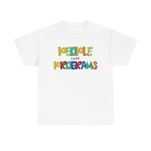 Könnte beinhalten: Weißes T-Shirt mit dem Text "PEOPLE over PROGRAMS" in bunten, verspielten Buchstaben. Der Text ist in einer verspielten Schriftart gehalten, wobei jedes Wort eine andere Farbe hat. Ein lässiges und bequemes T-Shirt.
