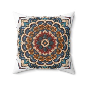 May include: A square throw pillow with a white background and a colourful mandala design in shades of blue, red, yellow, and brown. The mandala is intricate and detailed, with a central flower shape surrounded by layers of geometric patterns.