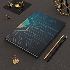 Peut inclure: Un carnet noir avec un motif de circuit imprimé en or et bleu. Le carnet est posé sur une surface grise avec deux crayons et quelques trombones.