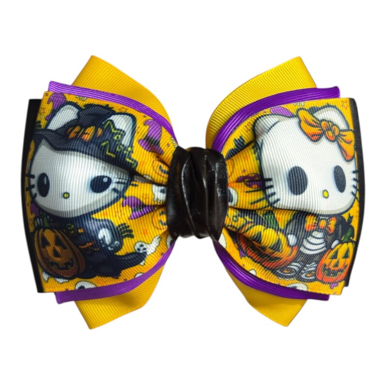 May include: A Halloween-themed hair bow featuring a cartoon cat character with a witch hat and pumpkin. The bow has yellow, purple, and black ribbons. The cat is white with black eyes and a black nose. The bow is decorated with Halloween imagery.