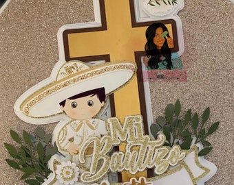 Peut inclure: Un topper de gâteau blanc avec une croix dorée, un garçon portant un costume blanc et un sombrero, une colombe et le texte "Mi Bautizo Matteo".