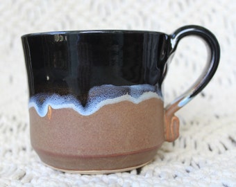 Ceramic mug, hand-thrown in shades of deep charcoal, blue and brown. Unique and sturdy hand-pulled handle fits comfortably in the hand.