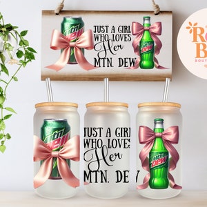 May include: Three frosted glass tumblers with lids and straws. Each tumbler features a different design: a can of Mountain Dew with a pink bow, the text "Just a girl who loves her Mountain Dew", and a bottle of Mountain Dew with a pink bow.