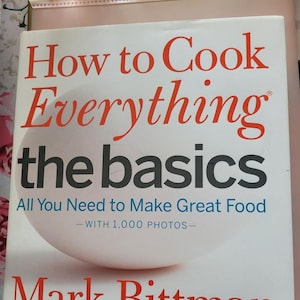 May include: A cookbook titled "How to Cook Everything the Basics" by Mark Bittman. The cover features the title in red and black text, with an image of an egg. The subtitle reads "All You Need to Make Great Food - WITH 1,000 PHOTOS-".