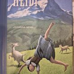 Può includere: Un libro intitolato "HEIDI" con un'illustrazione di montagna e una ragazza che fa la ruota. È visibile anche il nome dell'autore, JOHANNA SPYRI. La copertina presenta una ragazza con un vestito blu e due capre su un campo verde.