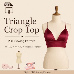 Pode incluir: Um top curto triangular bordô exibido em um manequim. O top tem alças finas e um acabamento acetinado. A imagem inclui o texto "Triangle Crop Top" e "PDF Sewing Pattern". Elementos adicionais incluem uma máquina de costura e uma fita métrica.