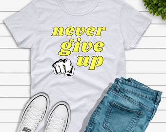 May include: White t-shirt with a yellow graphic that says "never give up" and a black fist image.