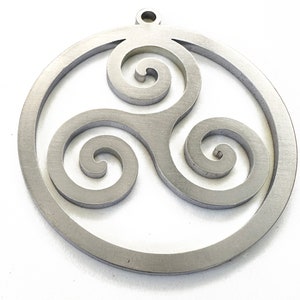 May include: A silver-colored pendant featuring a Celtic Triskelion design. The pendant is circular with a triple spiral symbol inside a circular frame. It has a small loop at the top for hanging.