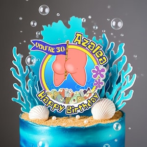 Puede incluir: Un adorno para tarta con diseño circular, una figura de estrella de mar rosa, detalles de coral azul y conchas blancas. El texto dice YOU'RE 30, AZALEA y Happy Birthday. El diseño incluye un borde amarillo y una base arenosa.