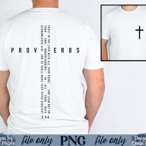 Peut inclure: T-shirt blanc avec le mot "PROVERBES" imprimé au dos. Une ligne verticale de texte indique "Fais confiance au Seigneur de tout ton cœur..." et la référence "3:5-6". Une petite image d'une croix est sur le devant.