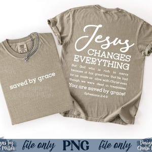 K&ouml;nnte beinhalten: Zwei olivgr&uuml;ne T-Shirts. Auf einem Shirt steht in wei&szlig;er Schrift "saved by grace". Das andere Shirt hat den Text "Jesus Changes Everything" mit einem Bibelvers. Die Shirts werden auf wei&szlig;em Hintergrund gezeigt.