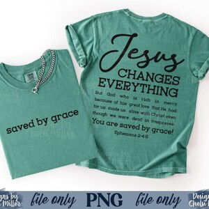 K&ouml;nnte beinhalten: Zwei teal-farbene T-Shirts. Eines hat den Text "saved by grace" in Schwarz. Das andere hat den Text "Jesus Changes Everything" mit einem Bibelvers. Eine silberne Halskette befindet sich auf dem ersten T-Shirt.
