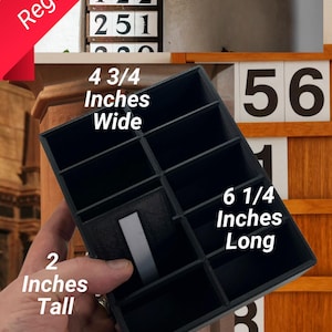 May include: A black plastic card holder with 12 compartments, measuring 4 3/4 inches wide, 6 1/4 inches long, and 2 inches tall. It holds standard 2-inch cards.