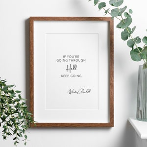May include: A framed print featuring a motivational quote by Winston Churchill: "If you're going through Hell, keep going."
