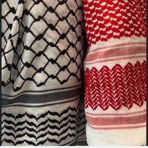 May include: Two different styles of traditional Palestinian keffiyeh scarves. One is black and white with a geometric pattern, the other is red and white with a geometric pattern.