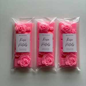May include: Three pink wax melts in clear plastic packaging. Each melt features a rose design and the text "Allure Wax Works Rose Petals Premium Soy Wax Melts Hand-Poured in Canada".