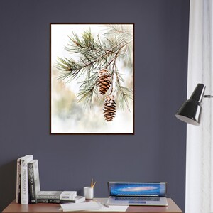 May include: A watercolor painting of a pine branch with three brown pine cones hanging from it. The background is a soft, blurred watercolor wash of white, green, and brown.