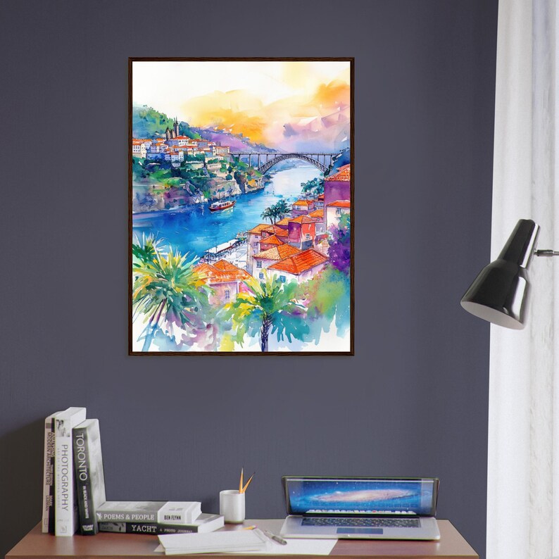 Op de afbeelding: Aquarel schilderij van een Europese kustplaats met een brug over een rivier. Het kunstwerk toont gebouwen met oranje daken, palmbomen en een boot op het water. De lucht gaat over van oranje naar paars.