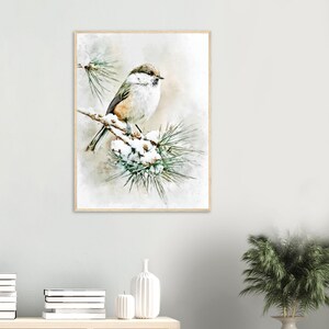May include: A framed watercolor print of a small bird perched on a snow-covered pine branch. The bird has brown, white, and gray feathers. The background is a soft, blurred wash of neutral tones, creating a serene winter scene.