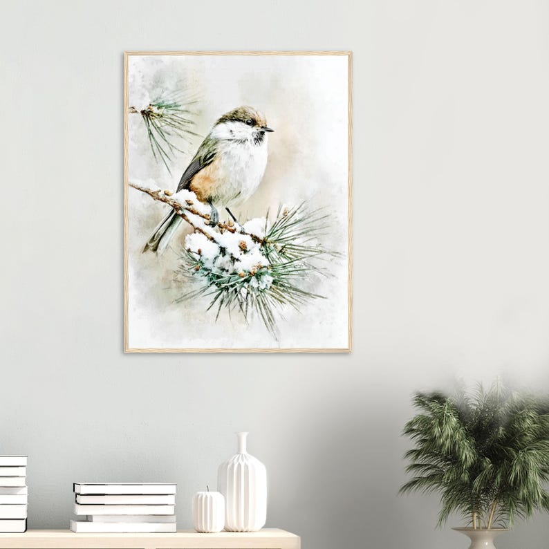 May include: A framed watercolor print of a small bird perched on a snow-covered pine branch. The bird has brown, white, and gray feathers. The background is a soft, blurred wash of neutral tones, creating a serene winter scene.
