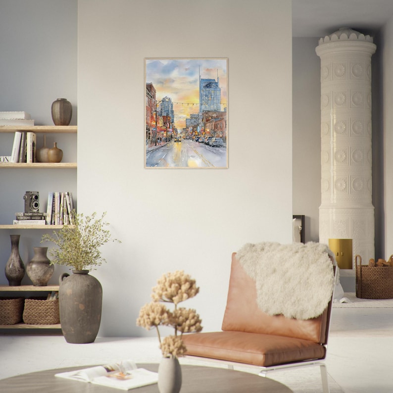 May include: A framed watercolor painting depicting a city street scene at sunset with tall buildings, glowing streetlights, and a golden sky. The artwork features a perspective view of a bustling urban road with warm orange and cool blue tones.