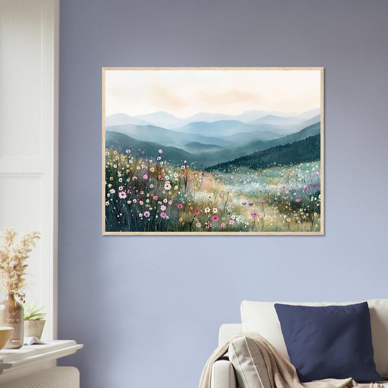 May include: A rectangular wall art print featuring a watercolor landscape of rolling blue mountains in the distance behind a foreground filled with a dense meadow of wildflowers in shades of pink, white, yellow, and green under a soft sky.