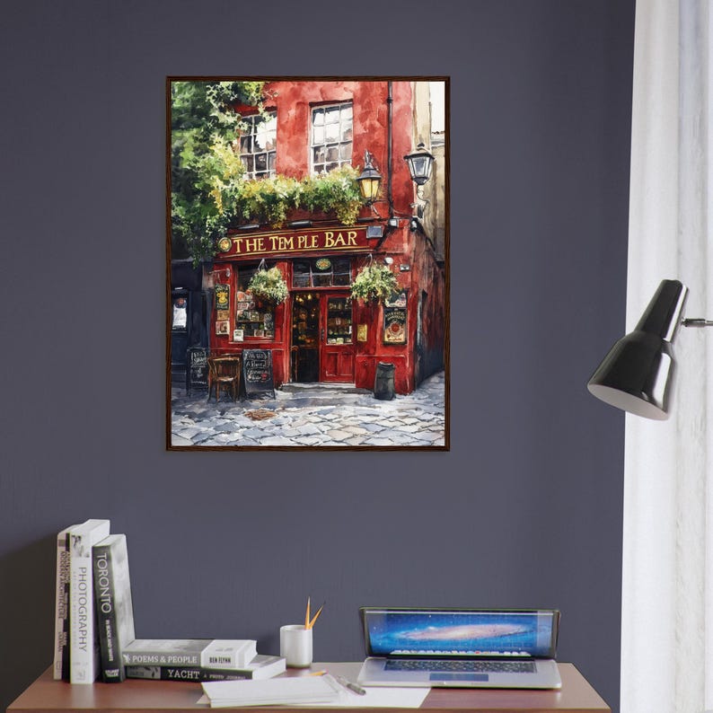 May include: A framed wall art print depicting the exterior of The Temple Bar, featuring a vibrant red facade, green foliage, and a cobblestone street. The painting captures the architectural details of the building with windows and signage.