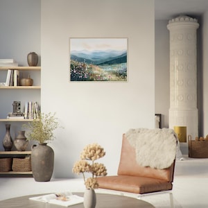 May include: A rectangular framed wall art print featuring a watercolor landscape of rolling blue mountains behind a vibrant meadow filled with colorful wildflowers in shades of pink, white, and yellow under a soft, pale sky.