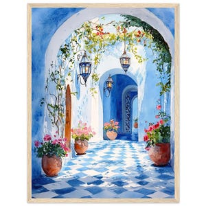 Op de afbeelding: Een aquarel schilderij van een blauwe en witte betegelde binnenplaats met een blauwe boog en hangende lantaarns. De binnenplaats is omgeven door witte muren en weelderig groen. Er staan ​​gepotte planten met roze bloemen aan weerszijden van de boog.