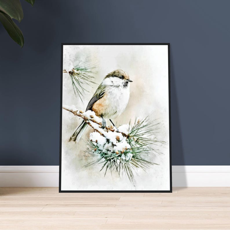 May include: A framed watercolor print of a small bird perched on a snow-covered pine branch. The bird has a white breast, brown back, and a dark head. The artwork is set against a soft, blurred background, creating a serene winter scene.
