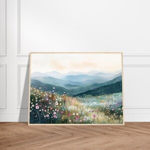 May include: A framed landscape print featuring a foreground of colorful wildflowers in shades of pink, white, and yellow, transitioning into a deep green forest and layers of soft blue mountains under a pale, hazy sky.