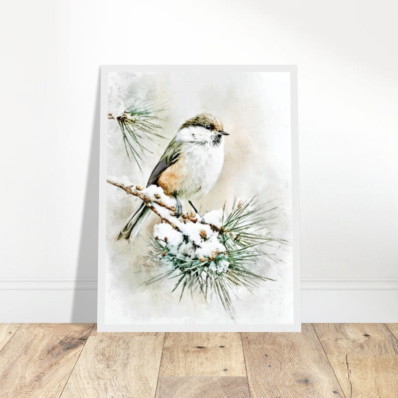 May include: A framed watercolor print of a small bird perched on a snow-covered pine branch. The bird has a brown head, white chest, and gray wings. The artwork has a soft, muted color palette with a winter theme.