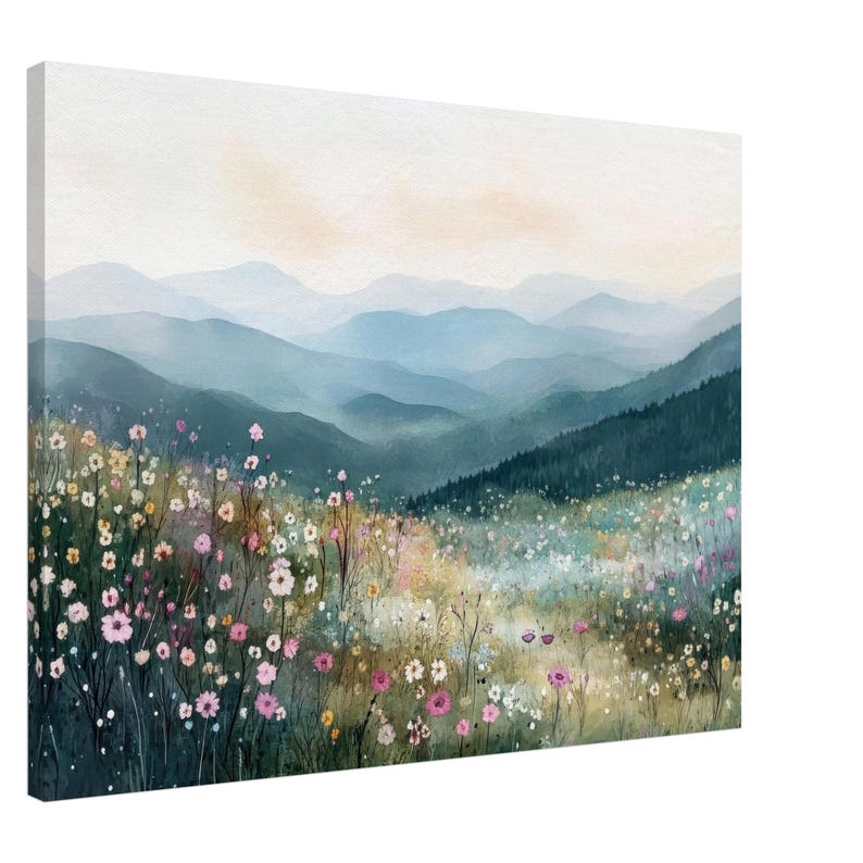 May include: A rectangular canvas wall art print featuring a watercolor landscape of rolling blue mountains in the distance behind a foreground meadow filled with various small pink, white, and yellow wildflowers and green foliage.