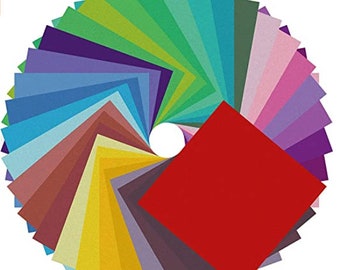 May include: A fan of 30 colourful origami paper squares in various shades of blue, green, purple, pink, red, yellow, brown, and grey. The paper is arranged in a circle with the red square in the centre.