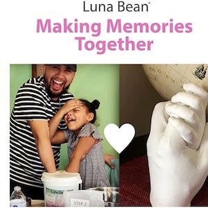 May include: A father and daughter are making a handprint keepsake together. The kit includes a white bucket of plaster, a heart-shaped mold, and a step-by-step guide. Luna Bean: Making Memories Together.