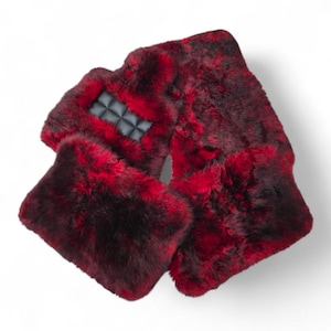 May include: A red and black faux fur scarf with a quilted black leather accent. The scarf is made of a soft, plush material and is designed to be worn around the neck. The scarf is a bold fashion accessory.