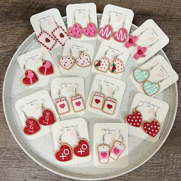 May include: Assortment of Valentine's Day themed earrings featuring various designs including hearts, cookies, jars, and coffee cups. The earrings are made of polymer clay and have silver hooks.
