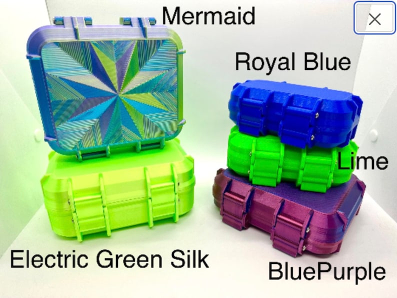 May include: Four small, rectangular storage cases in different colors. The cases are stacked on top of each other. The top case is a blue and green iridescent color and is labeled "Mermaid". The next case is a bright blue color and is labeled "Royal Blue". The next case is a bright green color and is labeled "Lime". The bottom case is a purple color and is labeled "BluePurple". The case on the left is a bright green color and is labeled "Electric Green Silk".